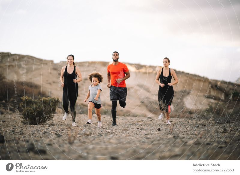 Active diverse family running on nature sportive active smile desert morning lifestyle together support health dynamic jogging multiethnic multiracial fitness