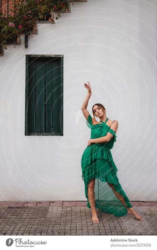 Barefoot woman leaning on house wall barefoot elegant exterior staircase street town stylish trendy window pot building pavement structure construction lady