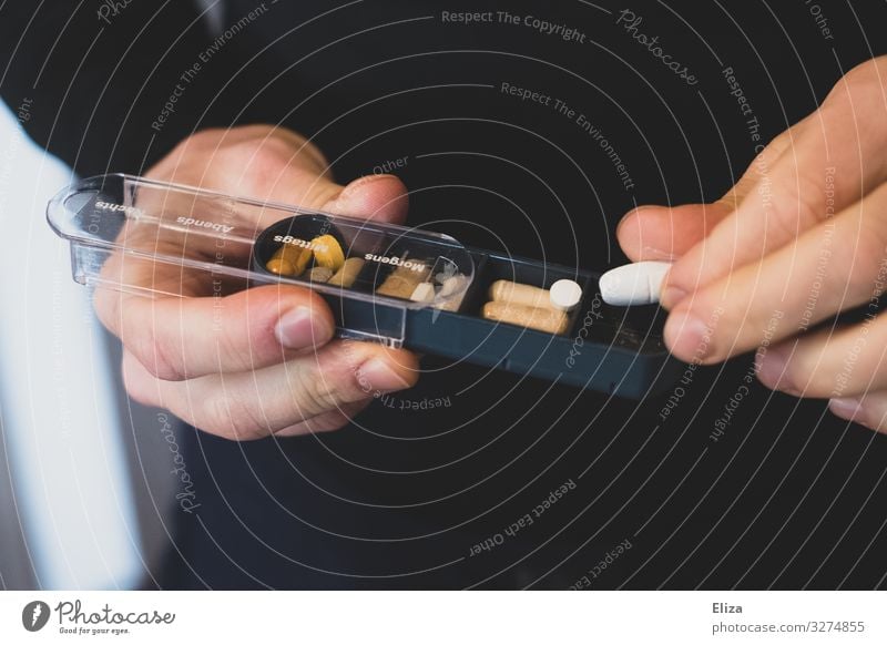 Hands holding a tablet box with pills and supplements and taking out a tablet Healthy Health care Healthy Eating Medication Masculine Pill pillbox