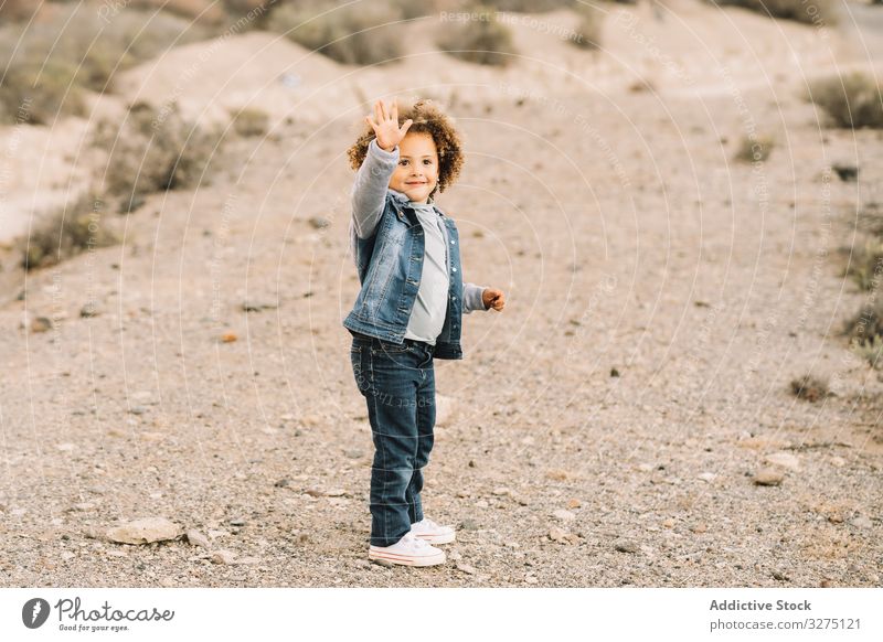 Ethnic curly toddler on nature child concentration pensive adorable focused wind girl casual human face portrait headshot appearance charming ethnic cute think