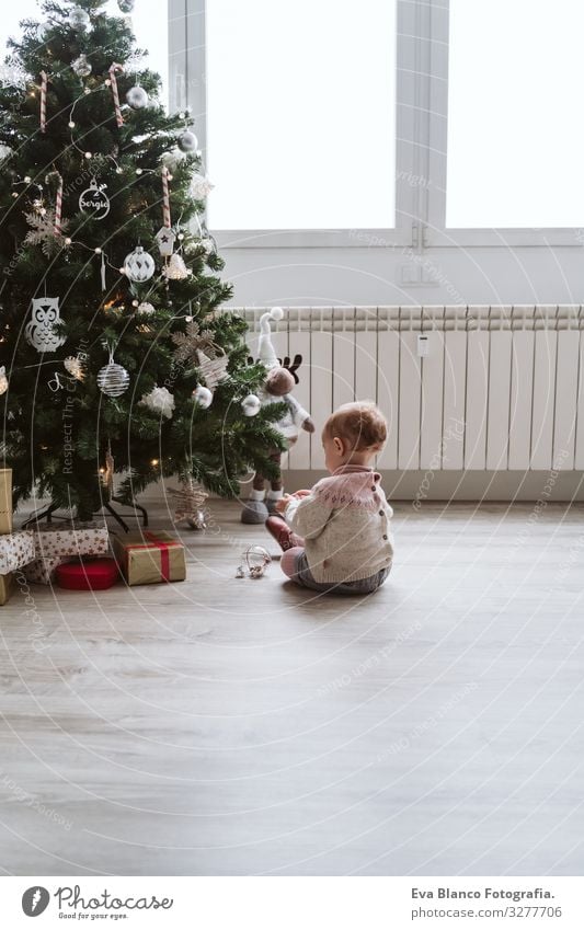 cute baby girl decorating the Christmas tree Happy Cute Baby Girl one year Christmas & Advent Tree Joy Family & Relations Love Decoration Infancy motherhood