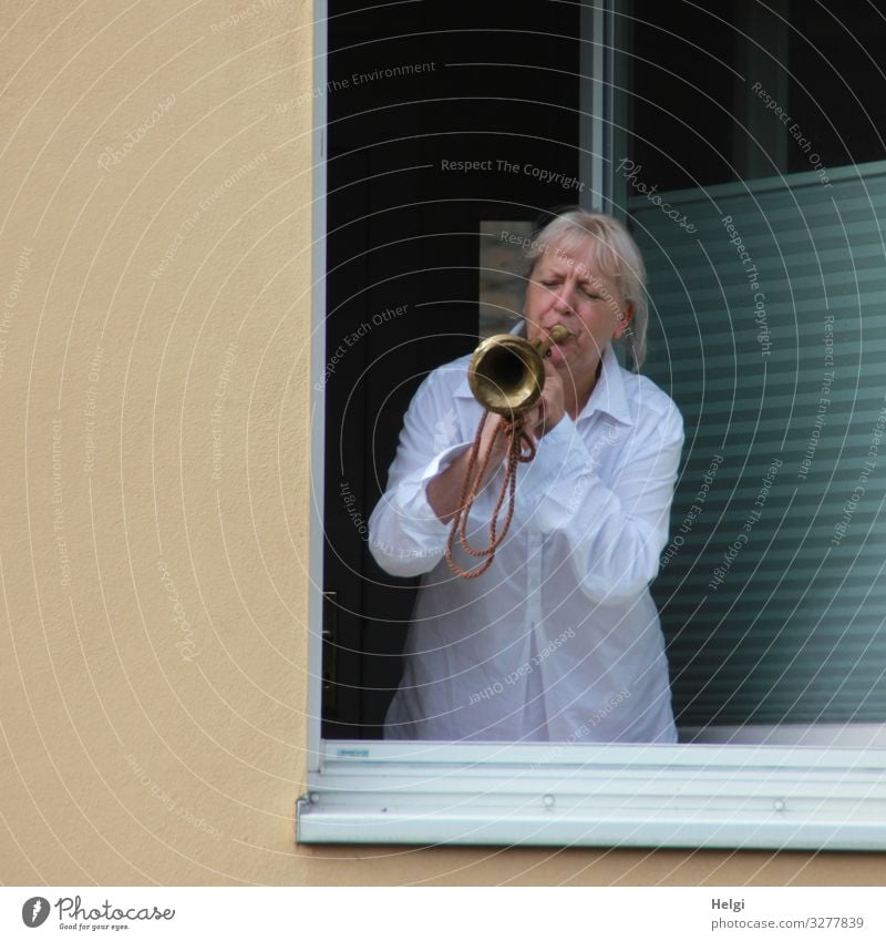 Woman stands at the open window and blows into a trumpet Human being Feminine Adults Female senior Senior citizen 1 45 - 60 years Wall (barrier) Wall (building)