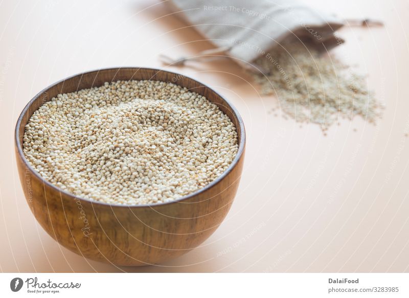 Uncooked Quinoa in wooden bowl with textil bag Nutrition Bowl Wood Diet Chenopodium background Cooking brown background Cereal copy space text food free gluten