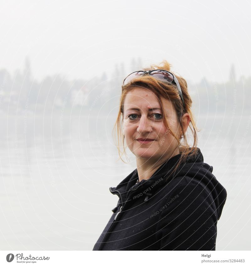 Portrait of a smiling woman with long brunette hair and dark jacket in a foggy landscape Human being Feminine Woman Adults 1 45 - 60 years Fog Lake Clothing