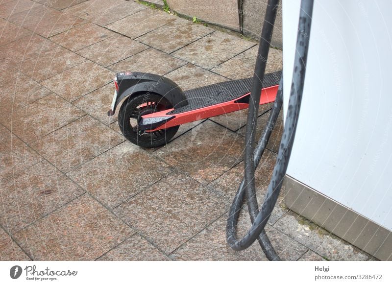 Electric scooter stands at a charging station Technology Advancement Future Energy industry Renewable energy Loading dock Cable Hamburg Town Port City