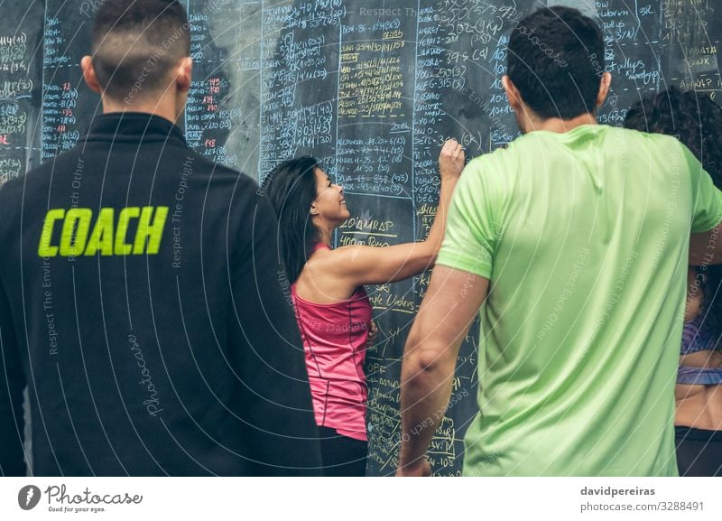 Athlete woman writing down results on the gym blackboard Lifestyle Sports Blackboard Student Human being Woman Adults Man Group Fitness Smiling sportswoman