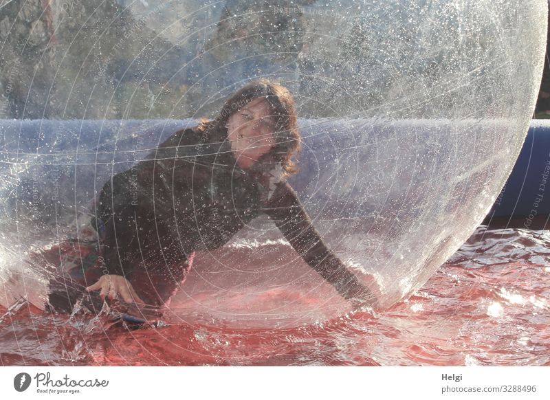 for bit.it - laughing young woman has fun in a plastic ball in a water basin Human being Woman Long-haired Brunette kind Laughter bubble Water basin Joy