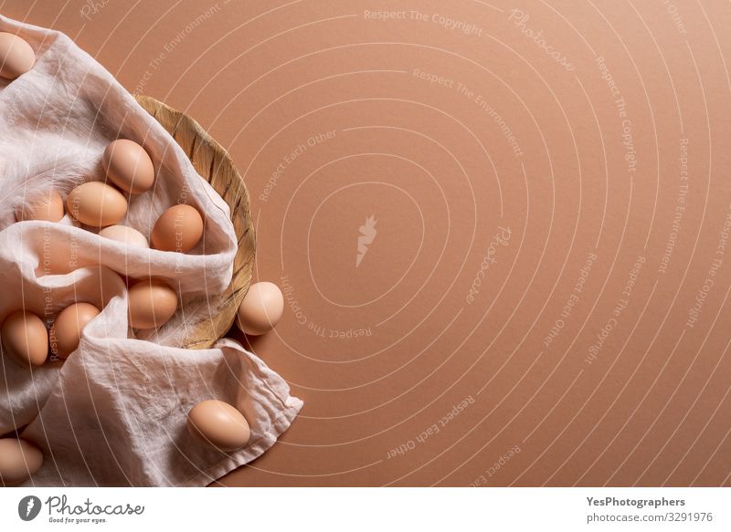 Eggs pile on brown background. Organic brown eggs. Fresh eggs Food Nutrition Diet Healthy Eating Natural above view chicken eggs Copy Space earth tones