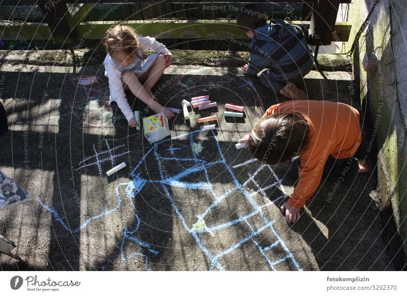 three children draw with chalk on a concrete floor Children's game terrace Girl Boy (child) Infancy 3 Human being 3 - 8 years Sign Line Draw Playing Small