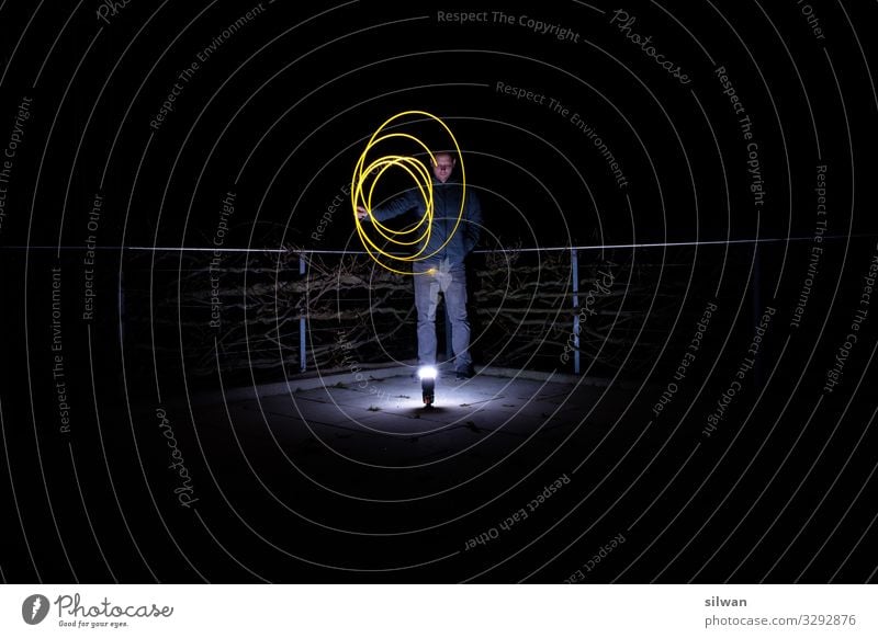 Man with circle of lights in the darkness Adults 1 Human being 18 - 30 years Youth (Young adults) Art Rotate Illuminate Make Threat Dark Glittering Hip & trendy