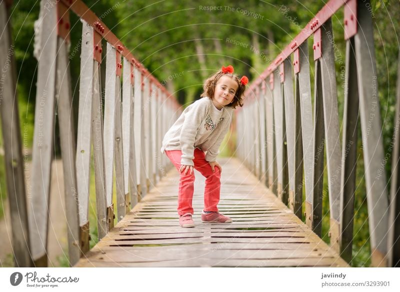 Cute little girl having fun in a rural bridge Joy Happy Beautiful Life Playing Child Human being Feminine Baby Woman Adults Infancy 1 3 - 8 years Nature Flower