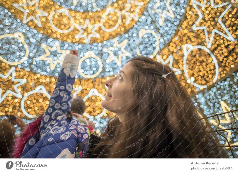 Mother and daughter in christmas tree indoors posing Lifestyle Happy Winter Decoration Mother's Day Child Woman Adults Family & Relations Tree Smiling Carrying