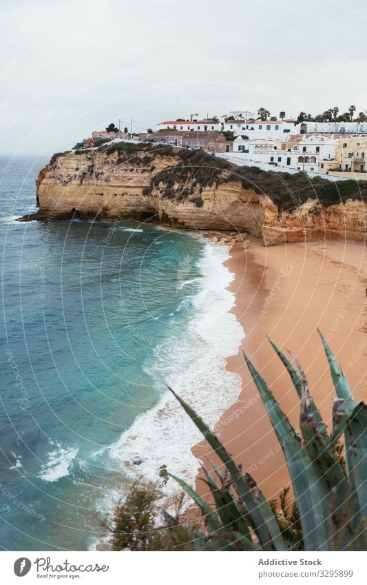 Sea waving near coastal town sea beach cliff wave cloudy sky storm portugal nobody weather water landscape scenic ocean house city settlement roll splash power