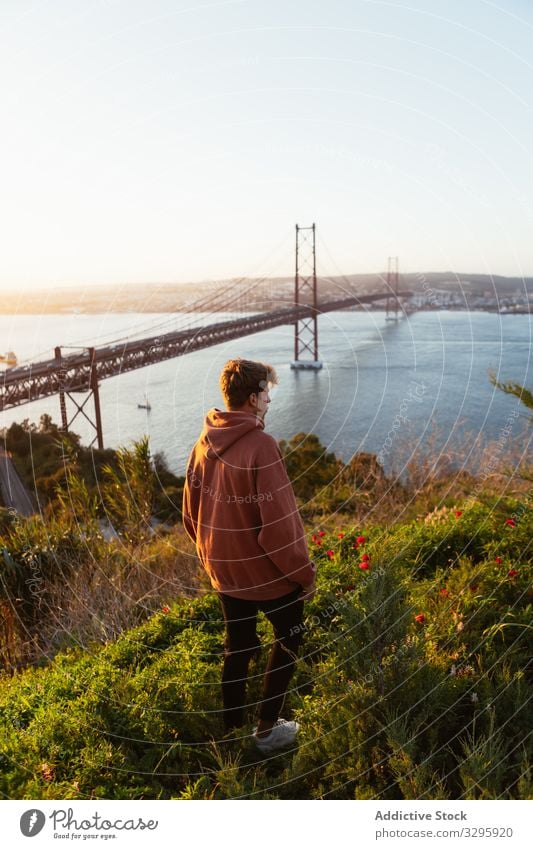 Unrecognizable male admiring bridge over river man admire evening suspension modern sky cloudless portugal landmark architecture building structure construction