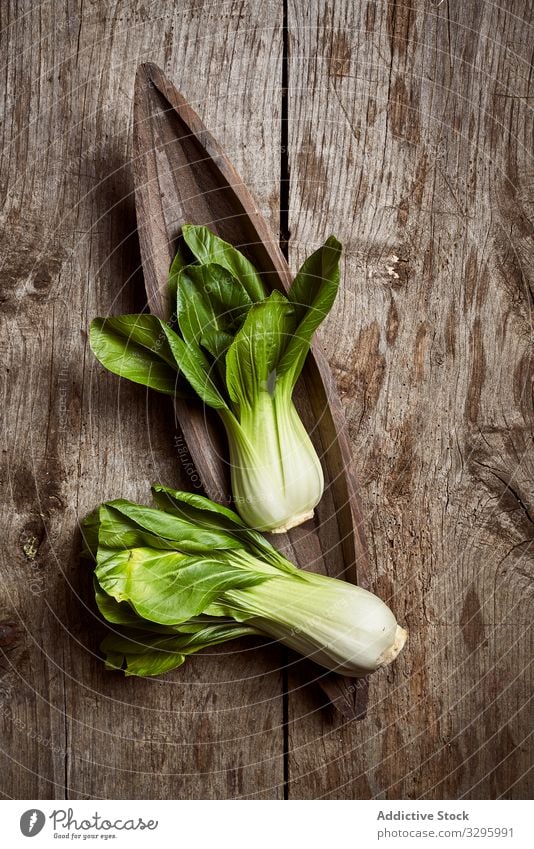 Bok choy on wooden table bok choy vegetable fresh ripe vintage plate shabby food green ingredient healthy raw leaf vegetarian vegan vitamin pak choi kitchen