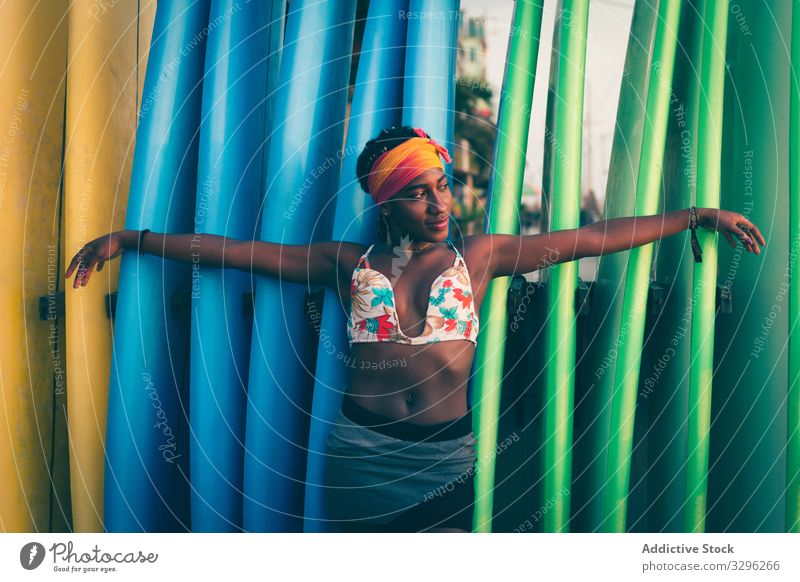 African American woman standing next to surf boards beach relax positive tranquil headband bikini colorful sea ocean enjoy calm style female outfit fashion