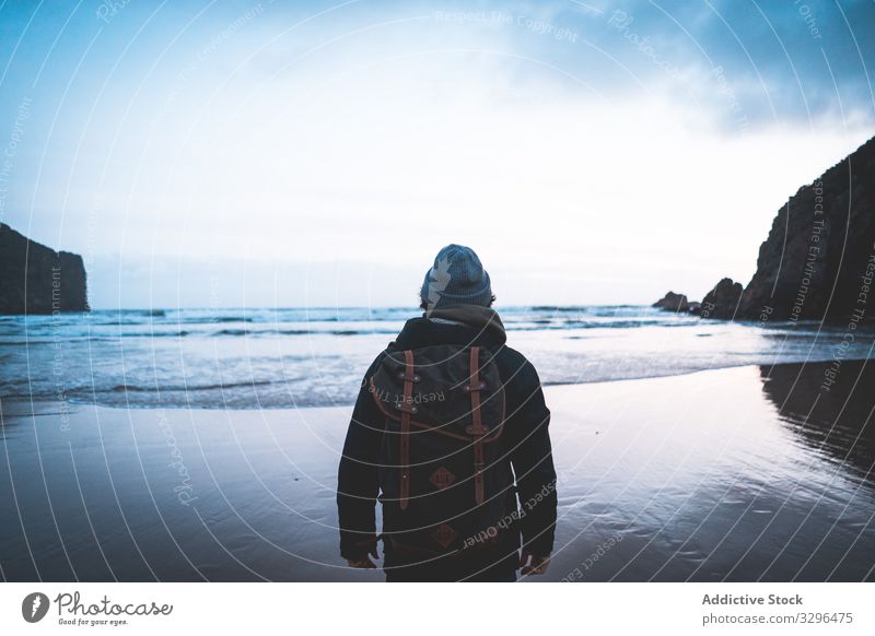 Man standing on seaside and contemplating moment traveler nature adventure mountain tourist vacation freedom wanderlust extreme breathtaking journey holiday