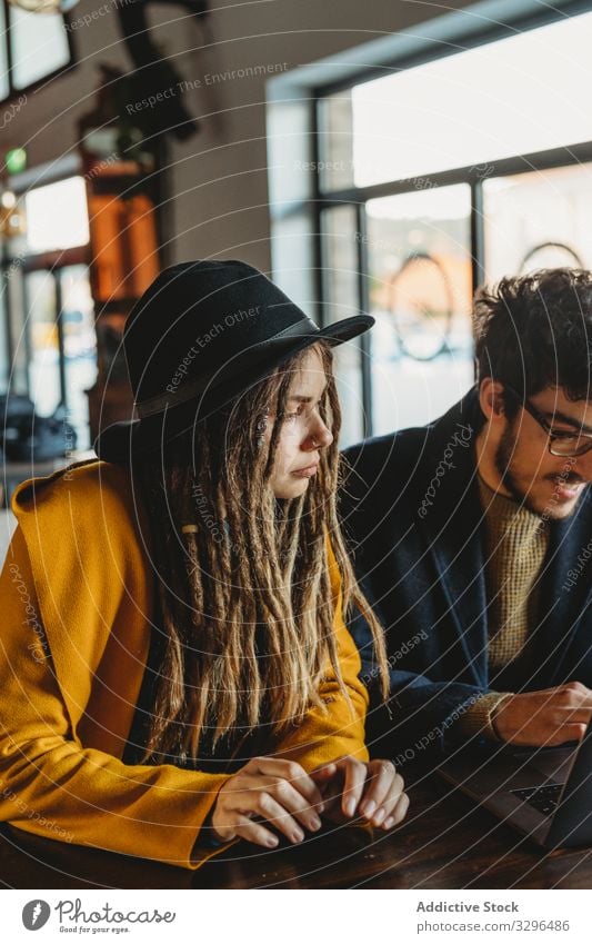 Stylish woman and man working on laptop in cafe people stylish student typing analyzing friendship start up content freelancer creative occupation device