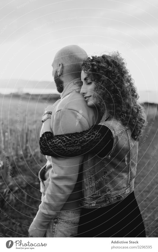 Hipster couple in love standing in field romantic embrace nature happy young together grass sit hug cuddle romance relationship tenderness happiness girlfriend