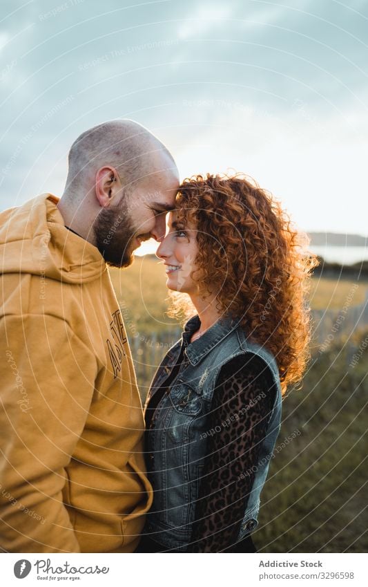 Hipster couple in love standing in field romantic embrace nature happy young together grass sit hug cuddle romance relationship tenderness happiness girlfriend