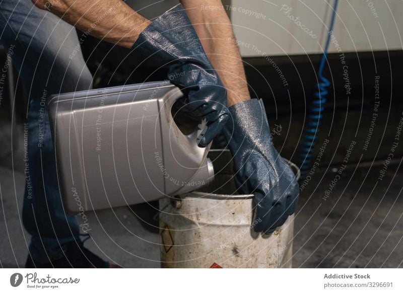 Faceless male employee working at workshop factory foreman pour canister liquid barrel gloves prepare safety industry protection occupation inversion