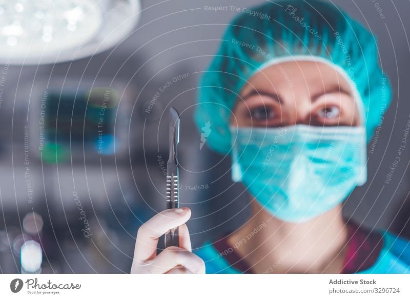 Female surgeon in operating theater hospital scalpel mask hat ready woman work doctor healthcare female sharp lancet sterile knife tool instrument job uniform