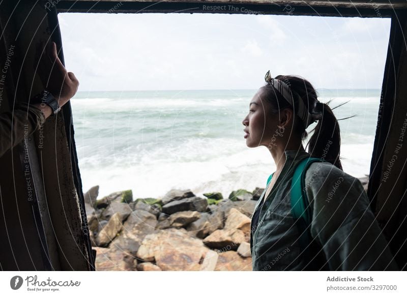 Curious female on vacation travelling by coastal train transport seashore woman curious doorway view beach seaside destination explore discovery lifestyle young