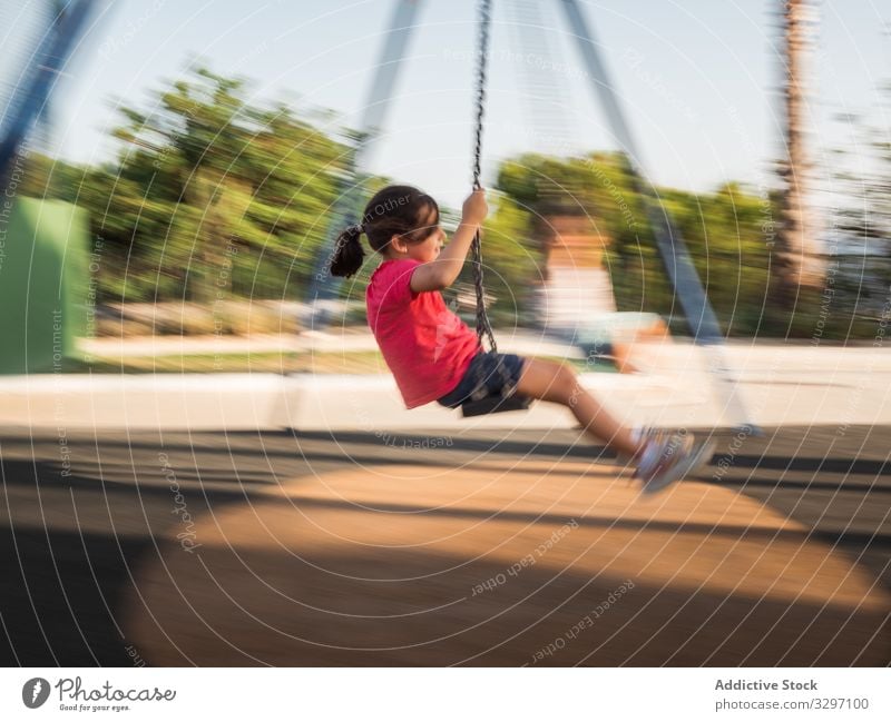 Girl on swing in park girl fun playground sunny daytime weekend summer season kid child casual activity childhood playful joy lifestyle rest relax motion