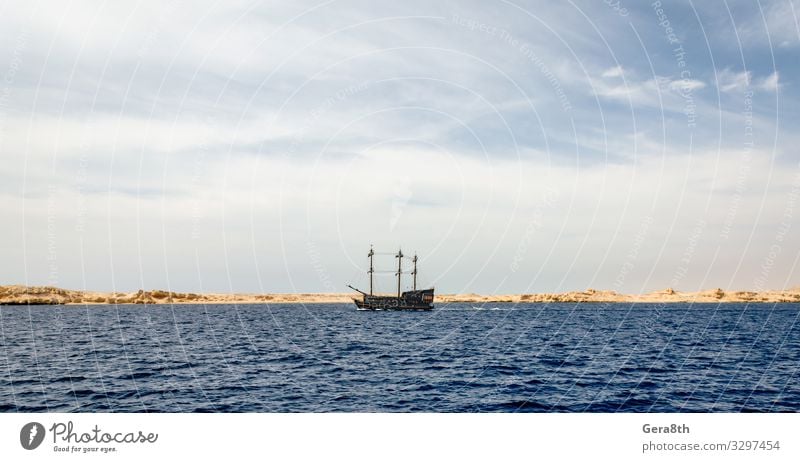 black yacht near the rocky shore of the Red Sea Exotic Vacation & Travel Tourism Trip Cruise Summer Ocean Island Nature Landscape Sand Sky Clouds Horizon