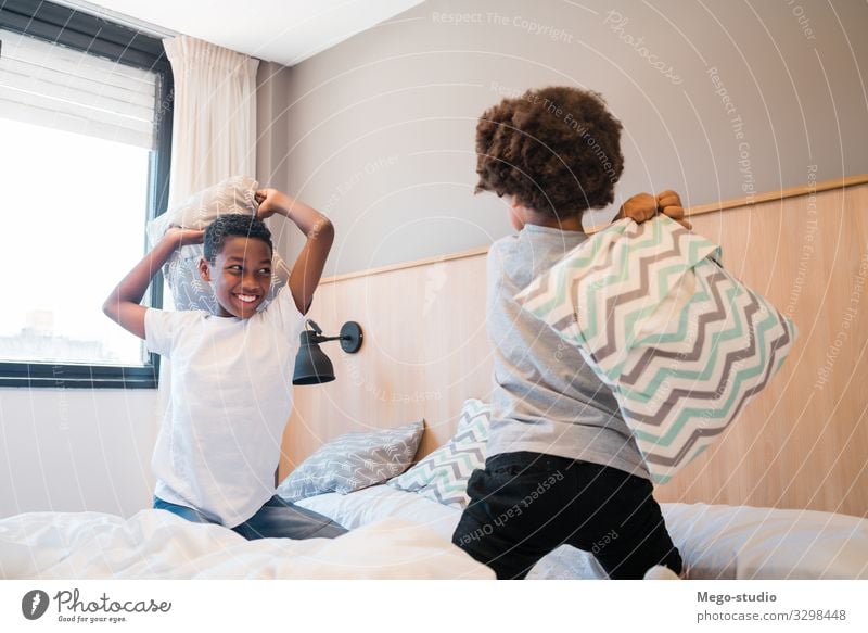 Two brothers playing with pillows at home. Lifestyle Joy Happy Leisure and hobbies Playing Bedroom Child Boy (child) Family & Relations Infancy Laughter