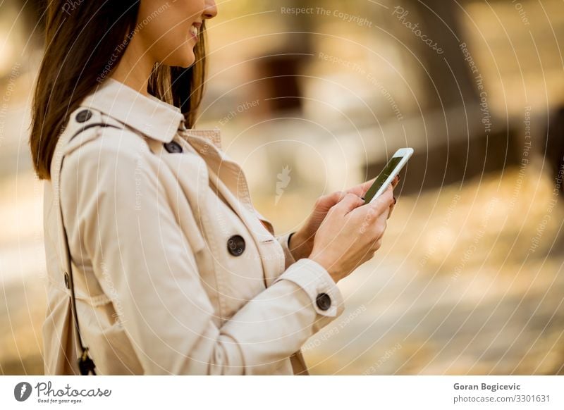 Happy young woman using cell phone in autumn park Lifestyle Beautiful Calm Telecommunications Telephone Technology Human being Feminine Young woman