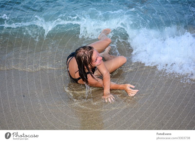 Young girl was knocked over by a wave, on a sandy beach by the sea Woman people funny joy frolicking vacation water frolicsome carefree Mediterranean France