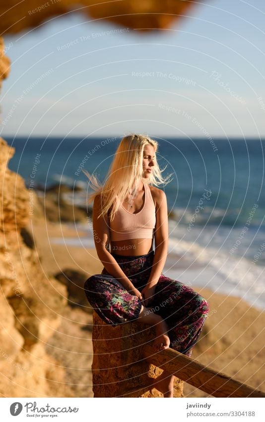 Young female sitting on beautiful stairs looking at the sea with golden light. Lifestyle Happy Beautiful Body Relaxation Meditation Leisure and hobbies