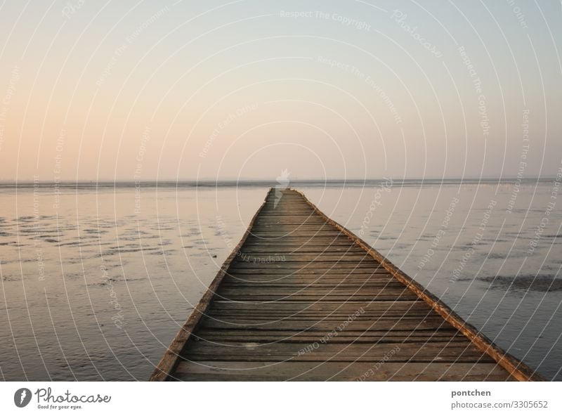 Long wooden footbridge leads out to sea. Sunset. Recreation, loneliness, idyllic Nature Elements Water Sky Cloudless sky Horizon Sunrise Beautiful weather