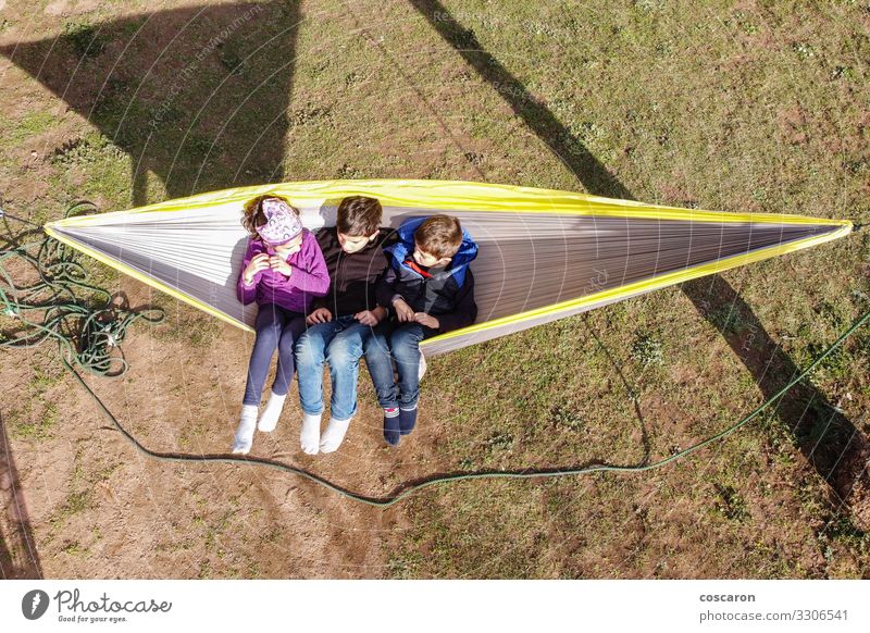 Three little kids sitting on a hammock Joy Happy Beautiful Relaxation Calm Leisure and hobbies Playing Summer Summer vacation Garden Child Human being Toddler