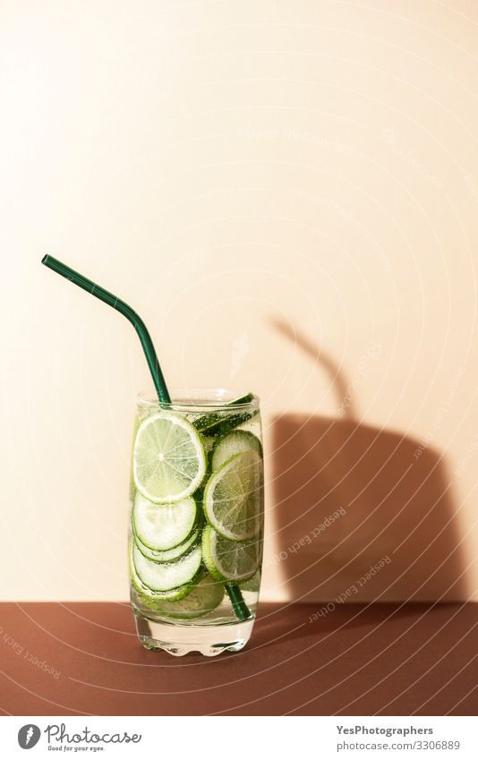 Cucumber and lime water.Cold green lemonade. Fruit Beverage Cold drink Lemonade Glass Straw Red antioxidant drink brown shades Copy Space cucumber and lime