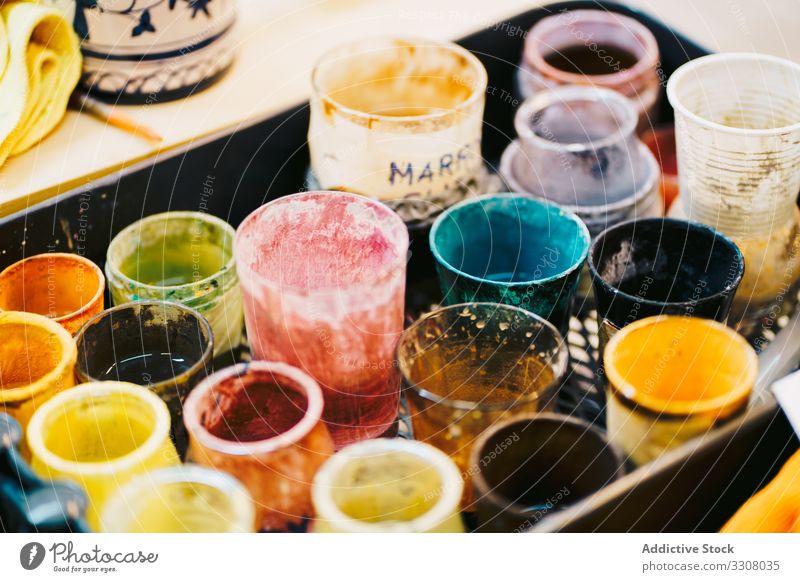 Glass cups with paints in workshop can palette multicolor glass lacquer diverse prepare mix shade used process composition arrangement layout inspiration art