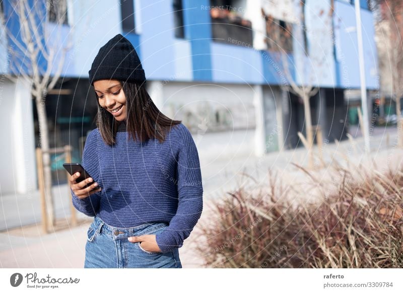 young beautiful woman standing while using a mobile phone Lifestyle Happy Beautiful Telephone PDA Technology Internet Human being Feminine Young woman