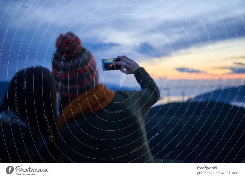 Two young women taking a selfie at sunset Lunch Lifestyle Joy Happy Vacation & Travel Summer Camera Human being Woman Adults Man Friendship Couple Hat Smiling