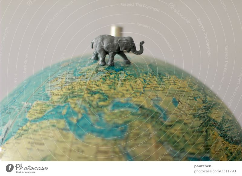 Toy elephant is on Globus. Climate change, animal welfare, endangered species Animal Wild animal Elephant 1 Plastic Cute Retro Globe Toys plastic animal Stand