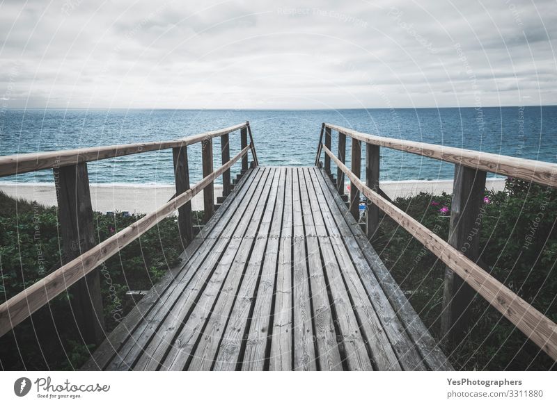 Wooden footpath towards sea on Sylt island on a rainy day Summer Ocean Sand North Sea Bridge Gloomy Moody Perspective Frisian island German beach Germany