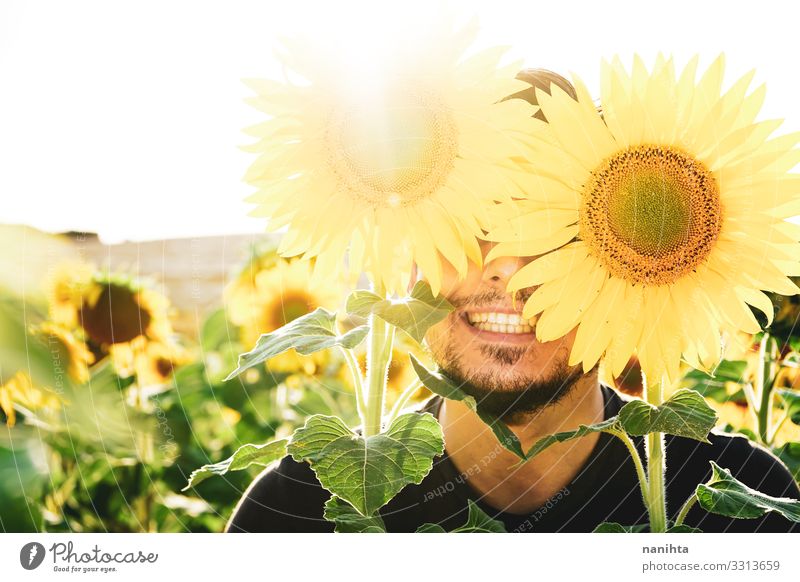 Young man enjoying the day in a field of sunflowers Face Life Sun Human being Masculine Man Adults Nature Spring Weather Beautiful weather Flower Beard To enjoy