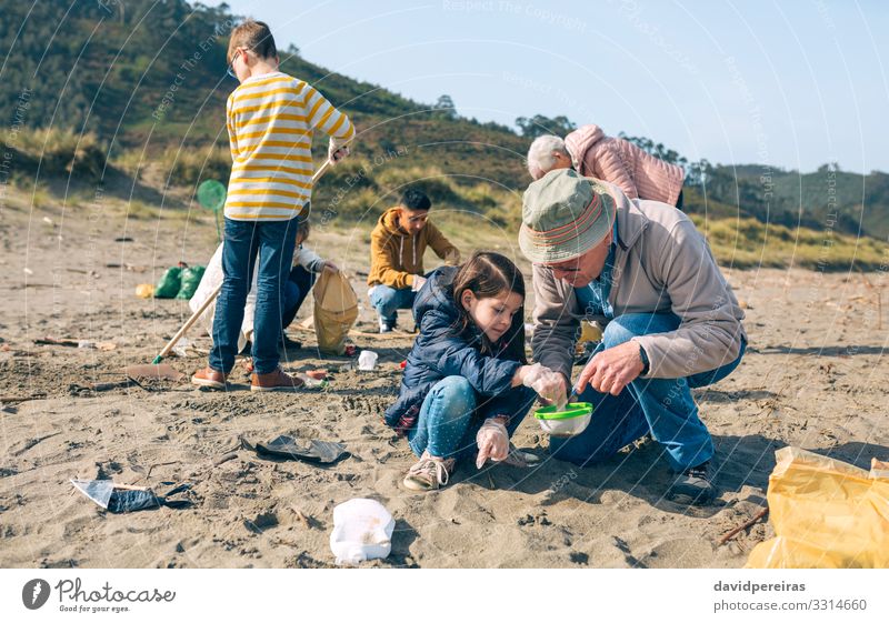 Volunteers cleaning the beach Beach Child Work and employment Human being Woman Adults Man Grandfather Family & Relations Group Environment Sand Sieve Plastic