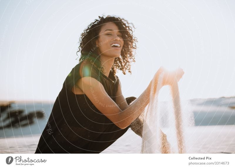 Beautiful African woman laughing and playing with beach sand Lifestyle Style Wellness Vacation & Travel Tourism Trip Adventure Freedom Beach