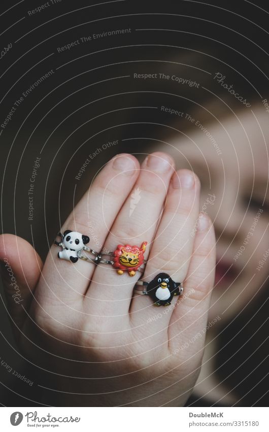 Girl proudly shows her three rings on her fingers Human being Feminine Child girl Infancy Head by hand Fingers 1 3 - 8 years Ring Animal Panda low Penguin