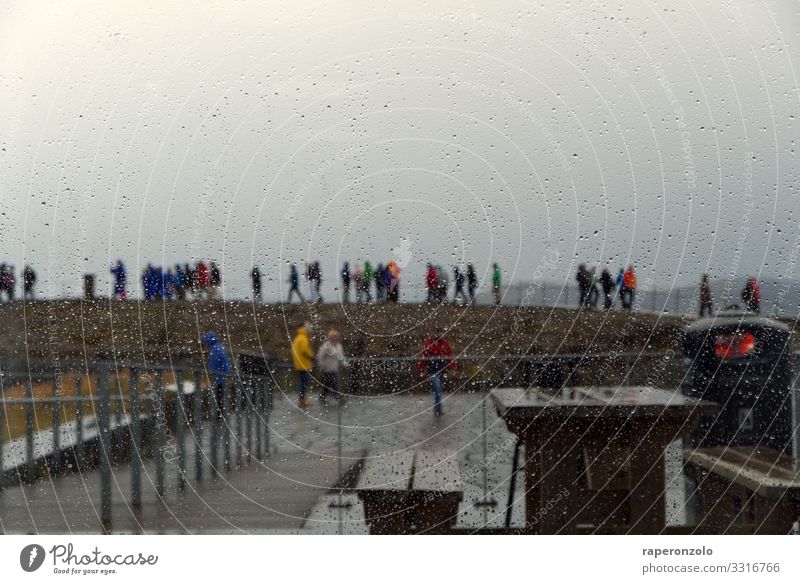 Tourists in small groups at a sight, photographed through a rain-wet window pane Rain raindrops Window pane rainy day Wet Drops of water Bad weather