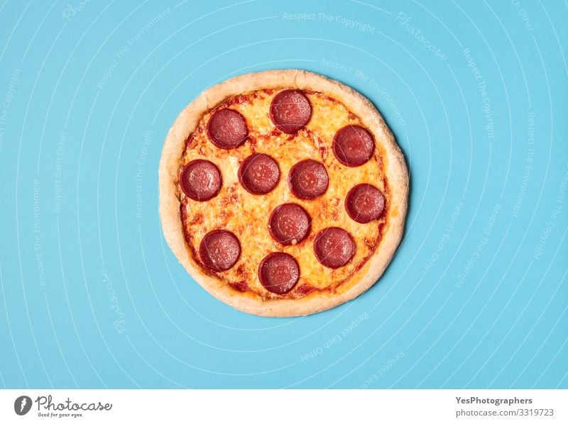 Pizza salami on a blue background. Whole pizza pepperoni. Food Dough Baked goods Nutrition Lunch Dinner Fast food Finger food Italian Food Delicious Blue Yellow