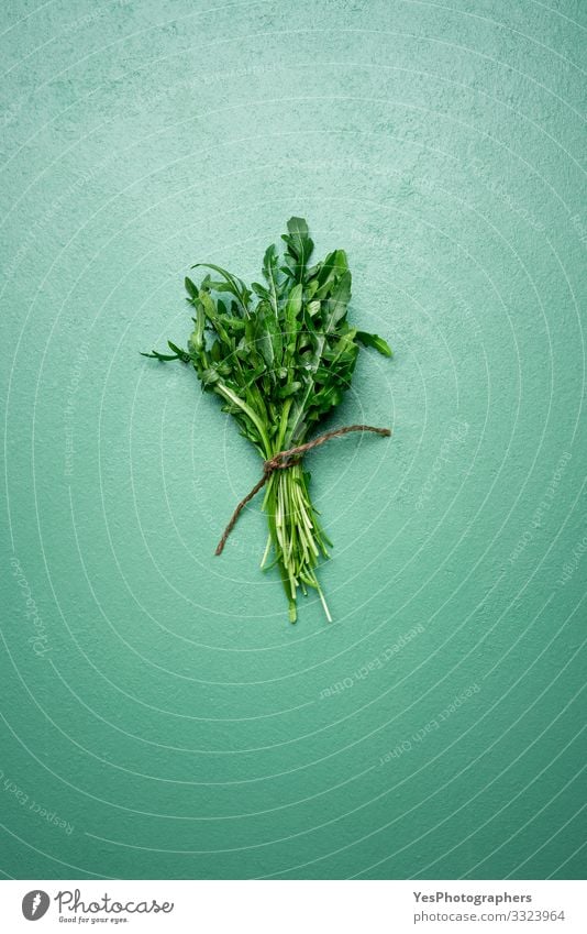 Fresh arugula leaves in a bouquet on green table. Arugula bundle Vegetable Lettuce Salad Organic produce Vegetarian diet Diet Healthy Eating Garden Gardening