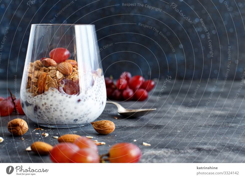 Chia pudding parfait with red grapes and almonds Yoghurt Fruit Dessert Eating Breakfast Diet Spoon Dark Gray White jar chia Bunch of grapes nuts Pudding seed