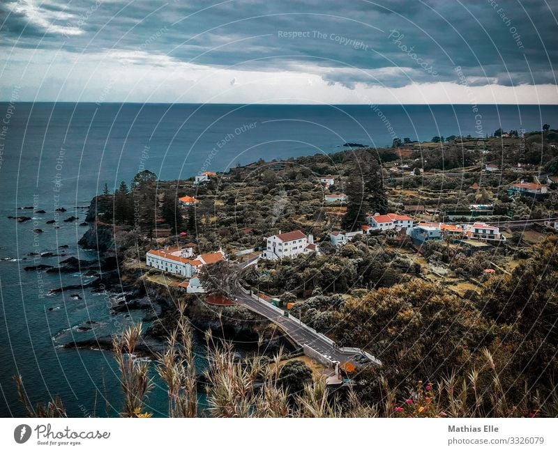 Small coastal town with white houses in the Azores Nature Water Clouds Storm clouds Summer Climate change Bad weather bushes hillock Coast Ocean Village